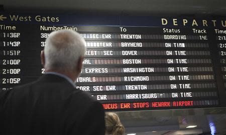 Travelers look at the schedule board at Penn Station in New York, November 26, 2013. REUTERS/Carlo Allegri