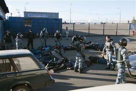 Russian police detain migrant workers during a raid at a vegetable warehouse complex in the Biryulyovo district of Moscow October 14, 2013. REUTERS/Ivan Stolpnikov