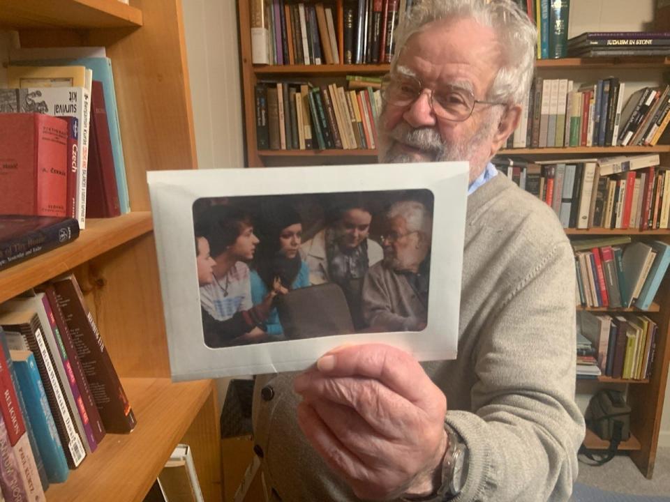 Walter Ziffer holds a picture of him meeting with students.