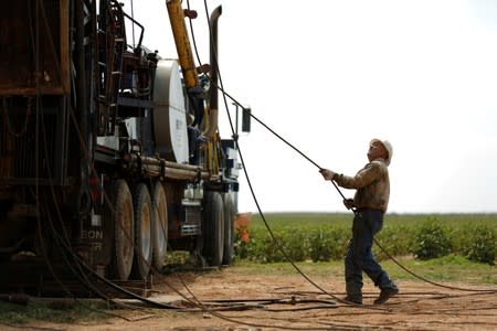Oil field worker, Miguel Holguin, operates a swabbing rig in a field in Seminole