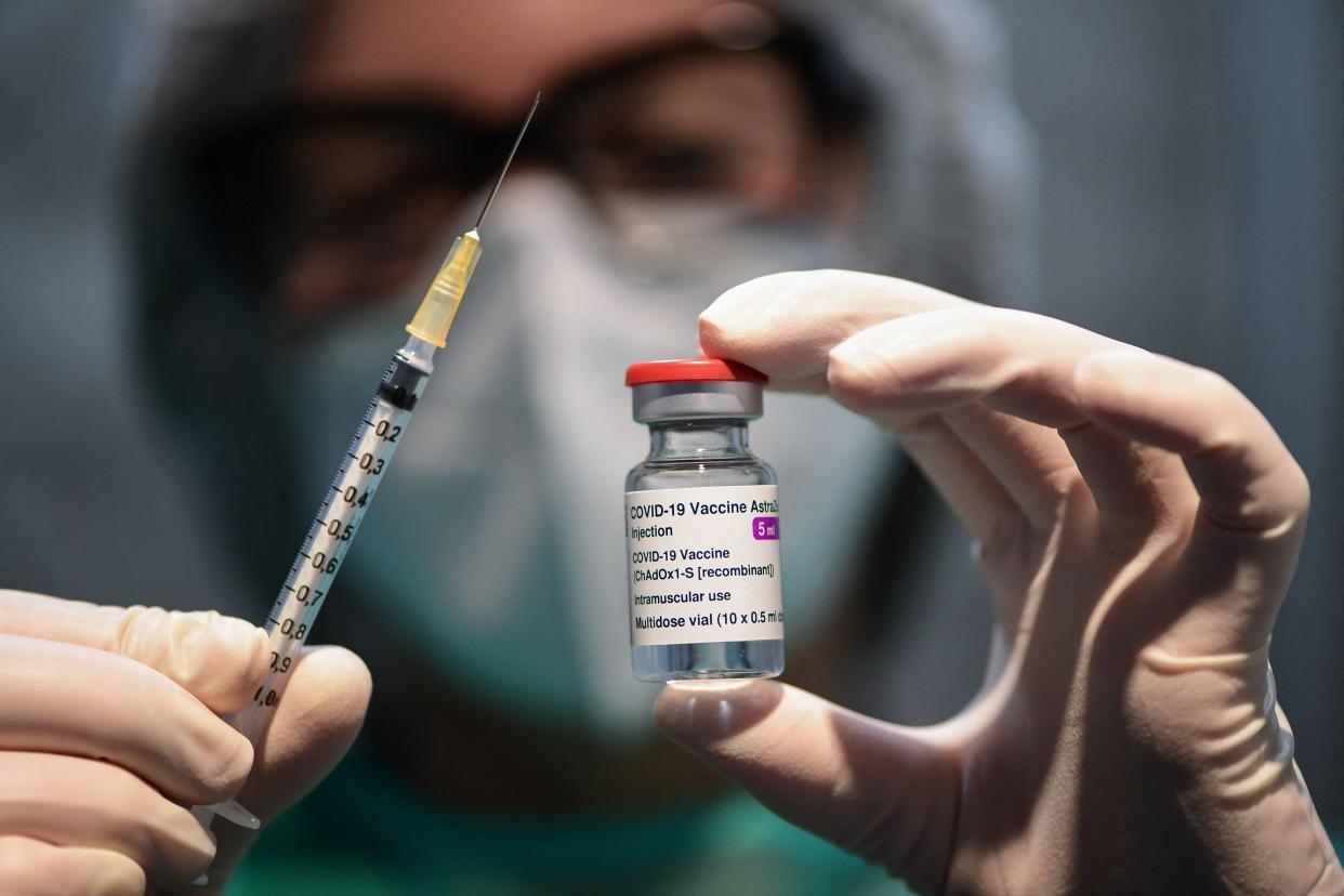 A European medical worker holds a syringe and vial of the AstraZeneca vaccine, which has been temporarily suspended after reports some patients developed blood clots (AFP via Getty Images)