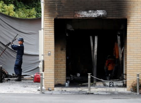 Firefighters conduct an investigation at the Kyoto Animation building which was torched by arson attack, in Kyoto