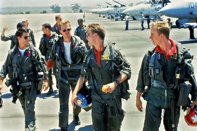 <p>Everett Collection</p> Tom Cruise, Anthony Edwards, Val Kilmer, and Barry Tubb in 'Top Gun'