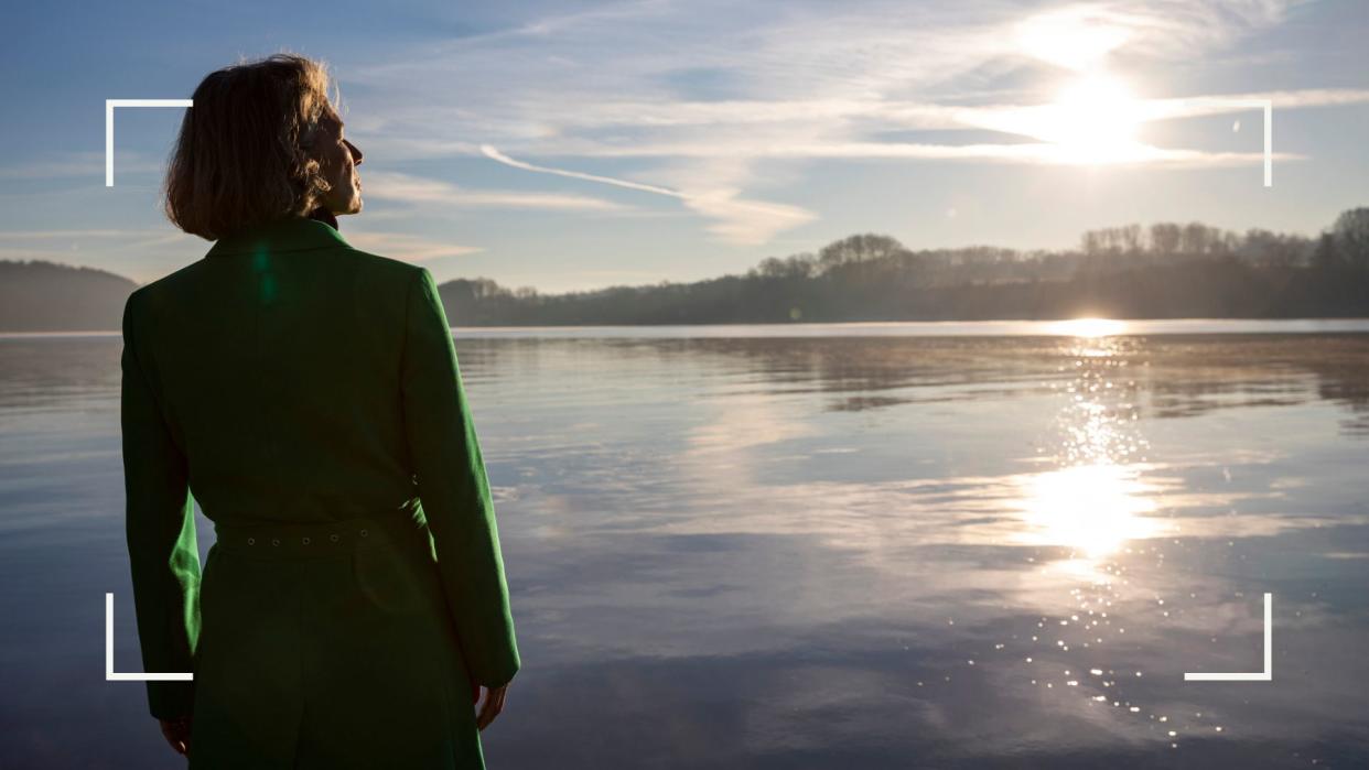  Woman on a beach looking out to sea. 