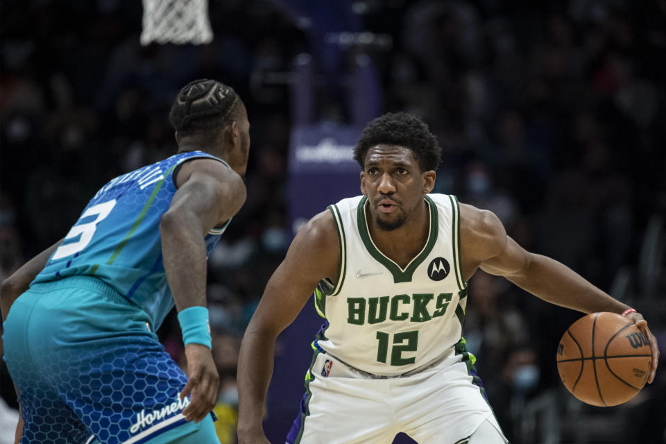 Milwaukee Bucks guard Langston Galloway (12) is defended by Charlotte Hornets guard Terry Rozier (3) during the first half of an NBA basketball game, Saturday, Jan. 8, 2022, in Charlotte, N.C. (AP Photo/Matt Kelley)