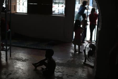 Children from Honduras, who will be accompanied by their families when they travel to reach northern Mexico or the U.S., stand at an entrance at the Todo por ellos (All for them) immigrant shelter in Tapachula, Chiapas, in southern Mexico, June 26, 2014. REUTERS/Jorge Dan Lopez