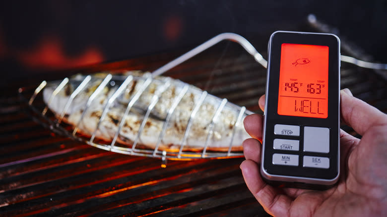 checking fish for doneness with thermometer