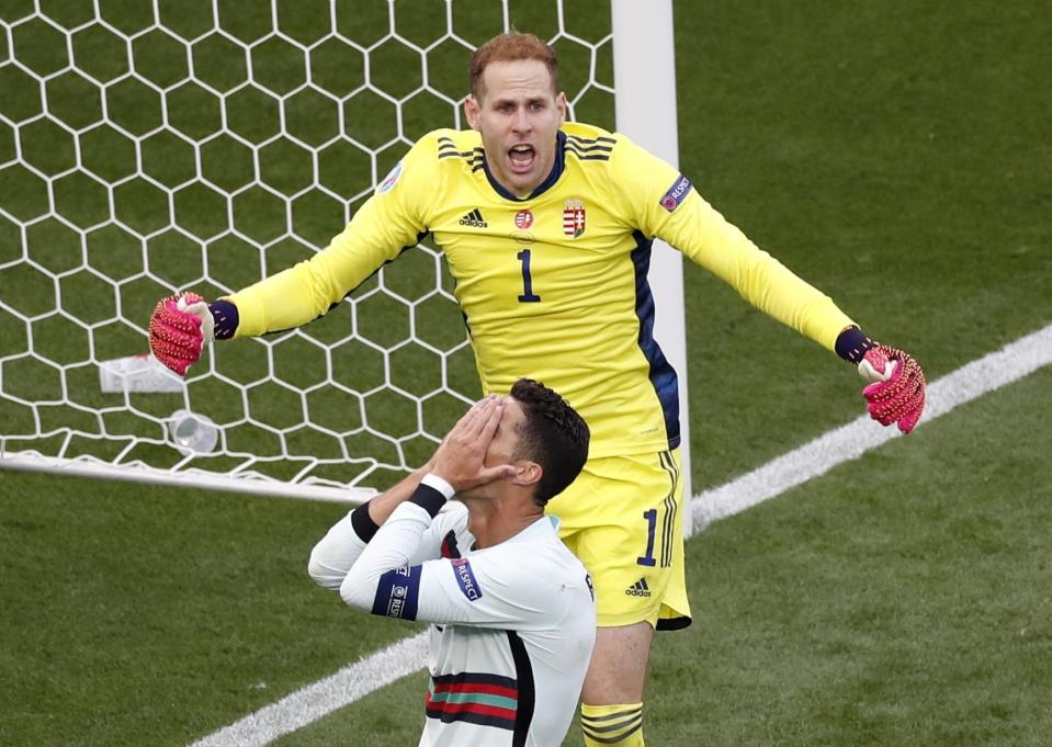 Portugal's Cristiano Ronaldo, foreground, reacts after failed to score as Hungary's goalkeeper Peter Gulacsi shouts to his teammates during the Euro 2020 soccer championship group F match between Hungary and Portugal at the Ferenc Puskas stadium in Budapest, Hungary, Tuesday, June 15, 2021. (AP Photo/Laszlo Balogh, Pool)