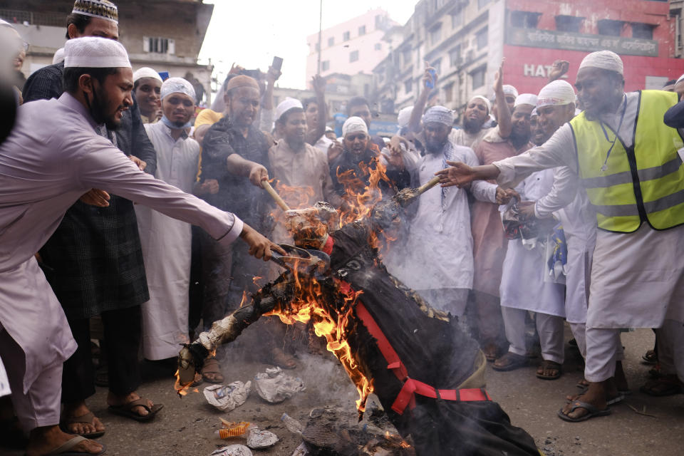 Bangladeshi Muslims protesting the French president’s support of secular laws allowing caricatures of the Prophet Muhammad march burn an effigy of French President Emmanuel Macron in Dhaka, Bangladesh, Monday, Nov.2, 2020. (AP Photo/Mahmud Hossain Opu)