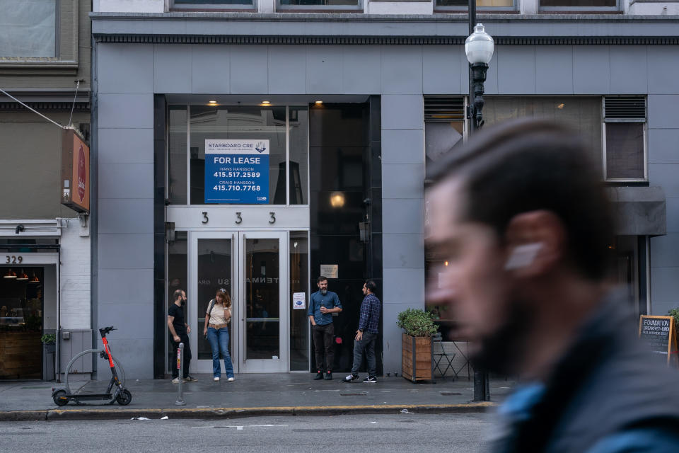 AI startup office workers stand outside a building for lease.