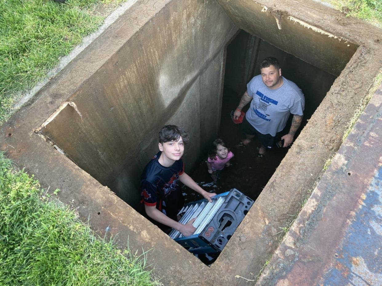 The Simon family, Shawn (right), Autumn, 5, and Shawn Jr., 14, look up from their Cold War era bomb shelter in Levittown, Pa. Shawn Simon is a plumber and said he recognizes professional grade construction, probably to government standards. "All I know is what I've been told by the realtor, that the guy who originally lived here at the that time was Air Force, and was in air support, and was a very important person for our national defense," he said.