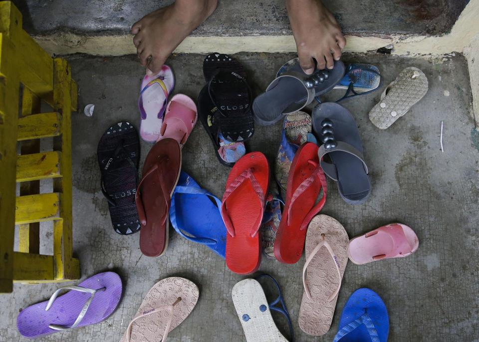 Sandals from evacuees pile outside their room at an evacuation center as rains from Typhoon Mangkhut begin to affect Tuguegarao city, Cagayan province, northeastern Philippines on Friday, Sept. 14, 2018. Typhoon Mangkhut retained its ferocious strength and slightly shifted toward more densely populated coastal provinces on Friday as it barreled closer to the northeastern Philippines, where a massive evacuation was underway. (AP Photo/Aaron Favila)