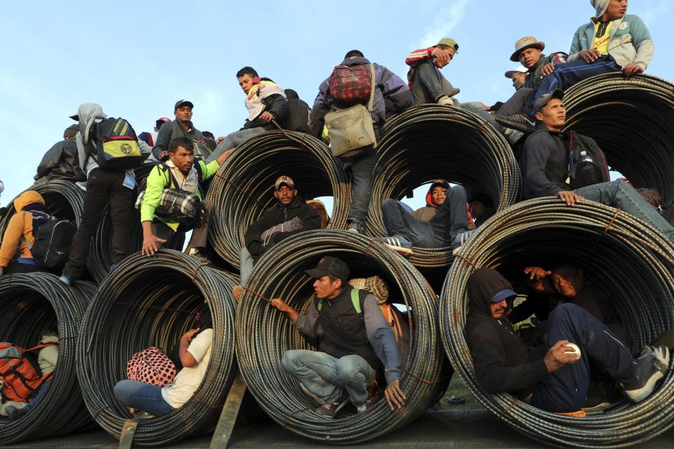 FILE - Central American migrants, part of the caravan hoping to reach the U.S. border, get a ride on a truck carrying rolls of steel rebar, in Irapuato, Mexico, Nov. 12, 2018, after a month on the road. (AP Photo/Rodrigo Abd, File)