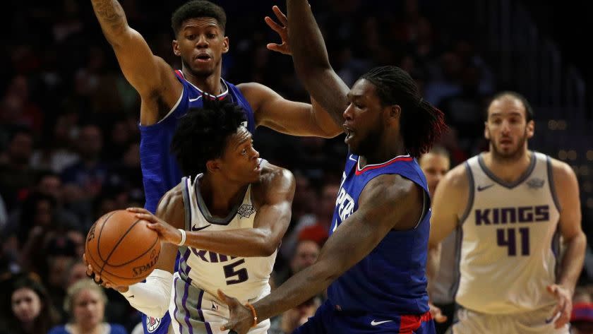 LOS ANGELES, CA - JANUARY 13, 2018:LA Clippers guard Tyrone Wallace (12) and LA Clippers forward Montrezl Harrell (5) double team Sacramento Kings guard De'Aaron Fox (5) in the second half on January 13, 2018 in Los Angeles, California.(Gina Ferazzi / Los Angeles Times)