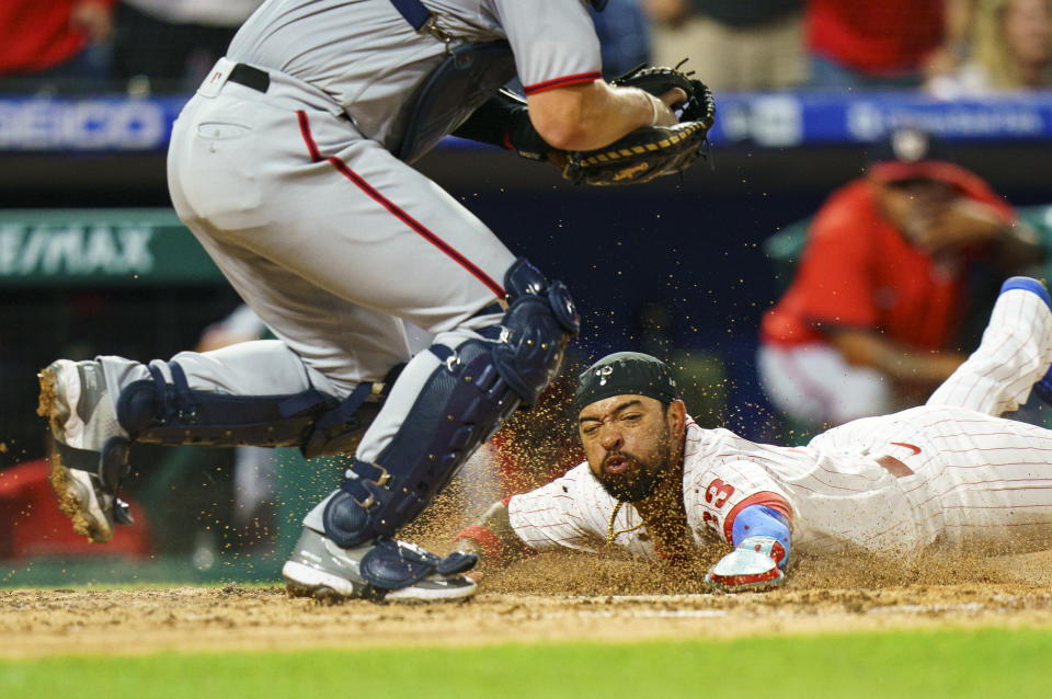 Philadelphia Phillies' Edmundo Sosa, right, slides into home on a double by Brandon Marsh as Washington Nationals catcher Riley Adams, left, waits for the ball during the fourth inning of a baseball game, Saturday, Sept. 10, 2022, in Philadelphia. (AP Photo/Chris Szagola)