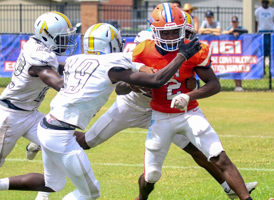 Bartow running back Trequan Jones fights for yards as Ridge Community's Vince Smith (22) and Elijah Cesaire (19) close in during last season's game.