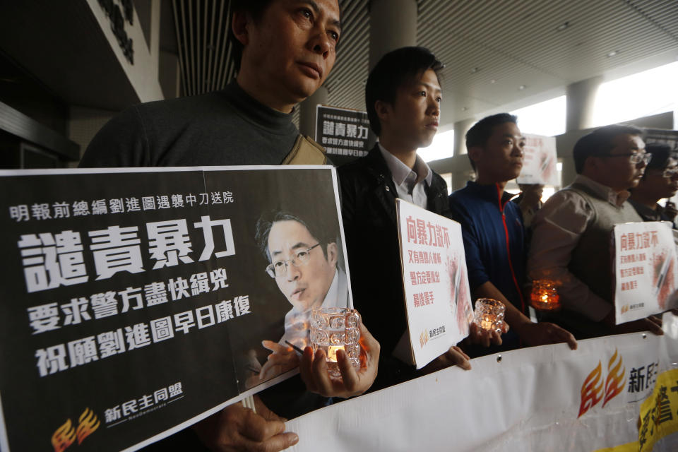 Pro-democracy protesters hold a picture of former Ming Pao chief editor Kevin Lau during a demonstration outside a hospital in Hong Kong Wednesday, Feb. 26, 2014. The former editor of the Hong Kong newspaper whose abrupt dismissal in January sparked protests over press freedom has been stabbed, police said on Wednesday. Police said a man wearing a motorcycle helmet “suddenly” attacked Kevin Lau on Wednesday morning with a knife and then fled on a motorcycle driven by another man. (AP Photo/Kin Cheung)