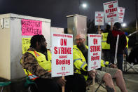 Solomon Hammond, 33, left, and John Olson, 45, right, both toolmakers at Boeing's Renton factory, hold picket signs after union members voted overwhelmingly to reject a contract offer and go on strike Friday, Sept. 13, 2024, outside the company's factory in Renton, Wash. (AP Photo/Lindsey Wasson)