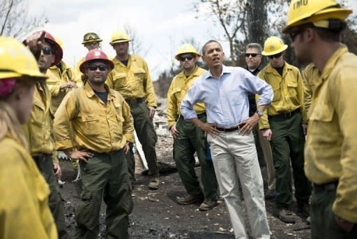 US President Barack Obama pauses with firefighters while touring the Mountain Shadow neighborhood which was burned by wildfires, on June 29 in Colorado Springs, Colorado. US firefighters reported progress Saturday in containing a deadly blaze that has killed two and left hundreds homeless in Colorado, as President Barack Obama hailed their efforts