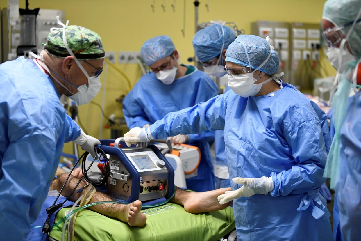Members of the medical staff in protective suits treat a patient suffering from coronavirus disease: REUTERS