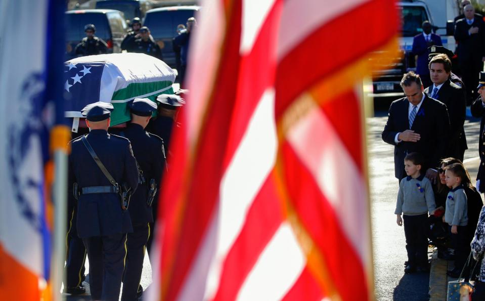 NYPD officers carry the casket of their slain fellow officer Paul Tuozzolo