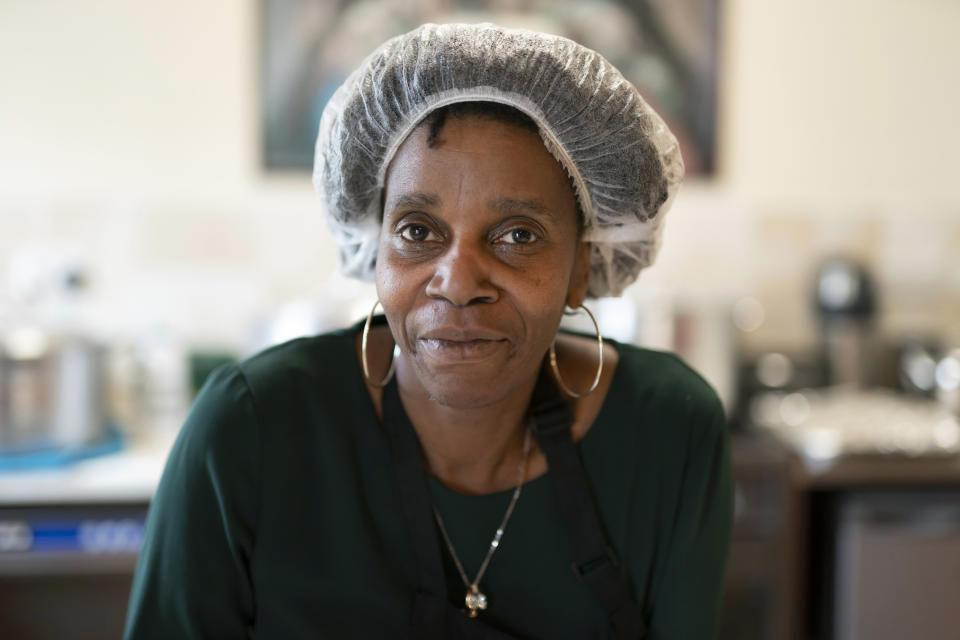 Chief coordinator Glenda Andrew poses for a photo as she prepares West Indian meals with members of the Preston Windrush Covid Response team, at the Xaverian Sanctuary in Preston, England, Friday Feb. 19, 2021. Once a week they distribute meals to people in Preston and surrounding communities in northwestern England that have recorded some of the U.K.’s highest coronavirus infection rates. The meal program grew out of Andrew’s work with Preston Windrush Generation & Descendants, a group organized to fight for the rights of early immigrants from the Caribbean and other former British colonies who found themselves threatened with deportation in recent years. (AP Photo/Jon Super)