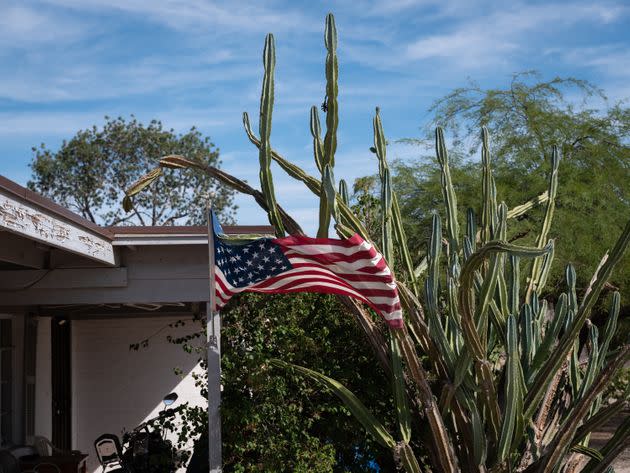 An American flag is caught in the spines of a cactus outside a home in Phoenix. (Photo: Molly Peters for HuffPost)