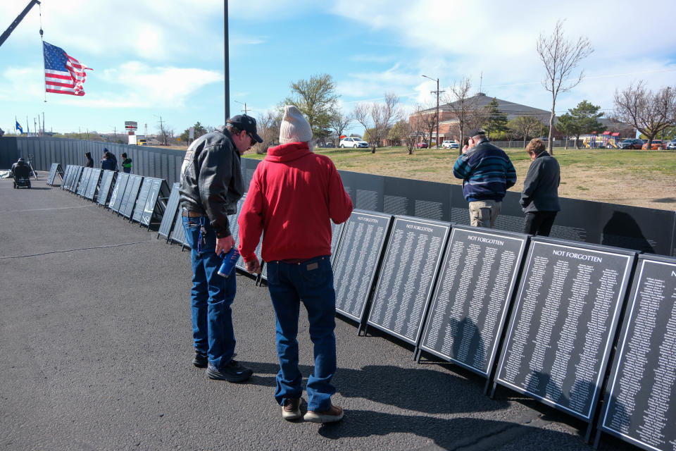 Attendees look over the wall at the opening ceremony for the Vietnam Traveling Memorial Wall Wednesday at the Ussery-Roan Texas State Veterans Home in Amarillo.