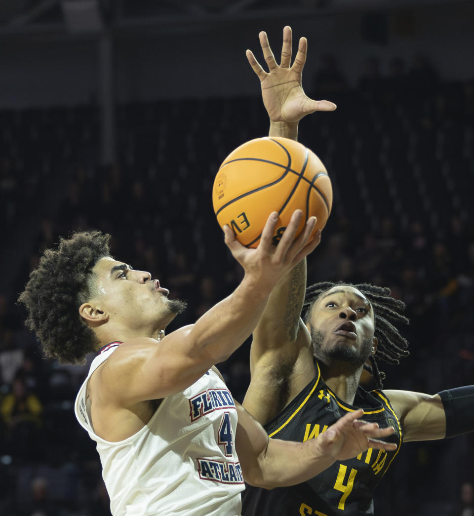 Florida Atlantic's Bryan Greenlee shoot against Wichita State defender Colby Rogers during the first half of an NCAA college basketball game on Sunday, Feb., 11, 2024, in Wichita, Kan. (Travis Heying/The Wichita Eagle via AP)