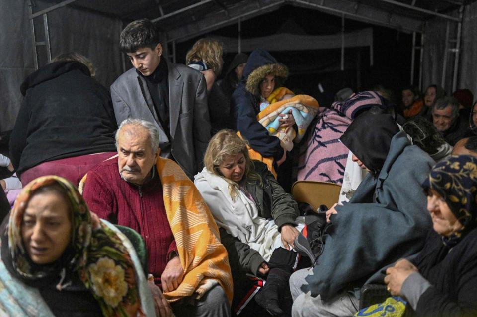 Earthquake survivors sit sheltering in a tent in Hatay (AFP via Getty Images)