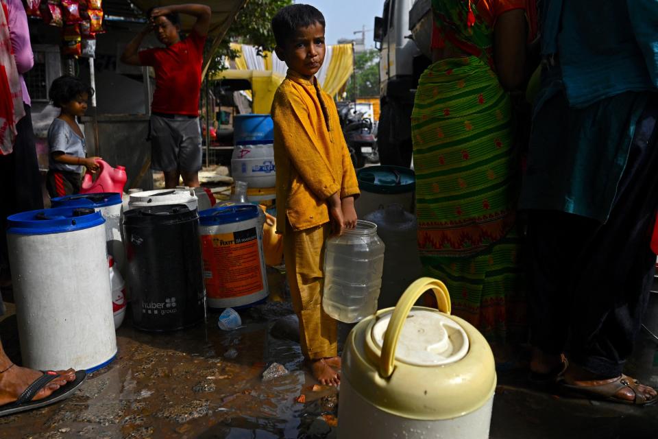 A boy stands in line to collect water from a tanker provided by the municipal corporation at a slum in New Delhi, India, as much of the country suffers under a record-breaking heat wave, May 18, 2022. / Credit: MONEY SHARMA/AFP/Getty