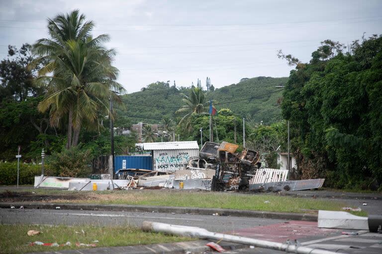 Autos quemados y barricadas se ven en un control de carretera a la entrada del distrito de Montravel en Noumea, territorio francés del Pacífico de Nueva Caledonia, el 21 de mayo de 2024. The unrest has left six people dead, including two police, and hundreds injured. (Photo by Delphine Mayeur / AFP)