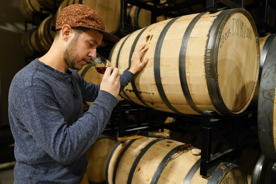 Eli Breitburg-Smith, head distiller and co-owner of Baltimore Spirits Company, checks the quality of rye whiskey from a barrel, Wednesday, Feb. 8, 2023, in Baltimore. Spirits have surpassed beer for U.S. market share supremacy, led by a resurgent cocktail culture — including the popularity of ready-to-drink concoctions, according to a spirits industry group. In 2022, spirits gained market share for the 13th straight year in the U.S. beverage alcohol market, with supplier sales reaching 42.1%, according to the Distilled Spirits Council of the United States. After years of steady growth, it marked the first time that spirits supplier revenues have surpassed beer, which holds a 41.9% market share, the group said. (AP Photo/Julio Cortez)