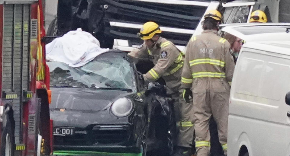 Emergency workers tend to the Porsche following the fatal collision. Source: AAP