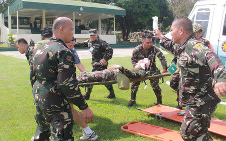 Soldiers carry on a stretcher a wounded member of Philippine President Rodrigo Duterte's presidential security group who was airlifted at an army camp in Cagayan de Oro after being hit in a roadside bomb attack in Lanao del Sur, Philippines November 29, 2016. Armed Forces of the Philippines/Handout via REUTERS