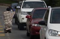 A homeless man begs for alms at a busy intersection in Johannesburg, Wednesday, Feb. 24, 2021. In Finance Minister's budget speech in Parliament, Tito Mboweni said the COVID-19 vaccination drive in the country will help South Africa's economy, the most developed in sub-Saharan Africa, to rebound by 3.4% this year after a statistics agency said the country's unemployment rate reached 32.5%. (AP Photo/Denis Farrell)