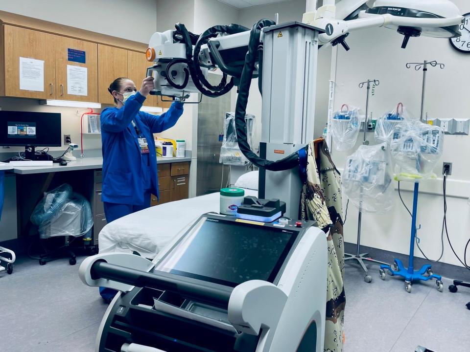 Sara Cosgray, the manager of imaging services at IU Health White Memorial Hospital, demonstrates a portable X-ray machine purchased through grant funding.