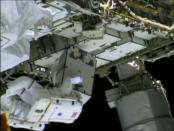 NASA astronaut Chris Cassidy (striped spacesuit) holds an ammonia pump control box during a spacewalk to hunt for an ammonia leak outside the International Space Station on May 13, 2013. The spacesuit of astronaut Tom Marshburn can be seen behi