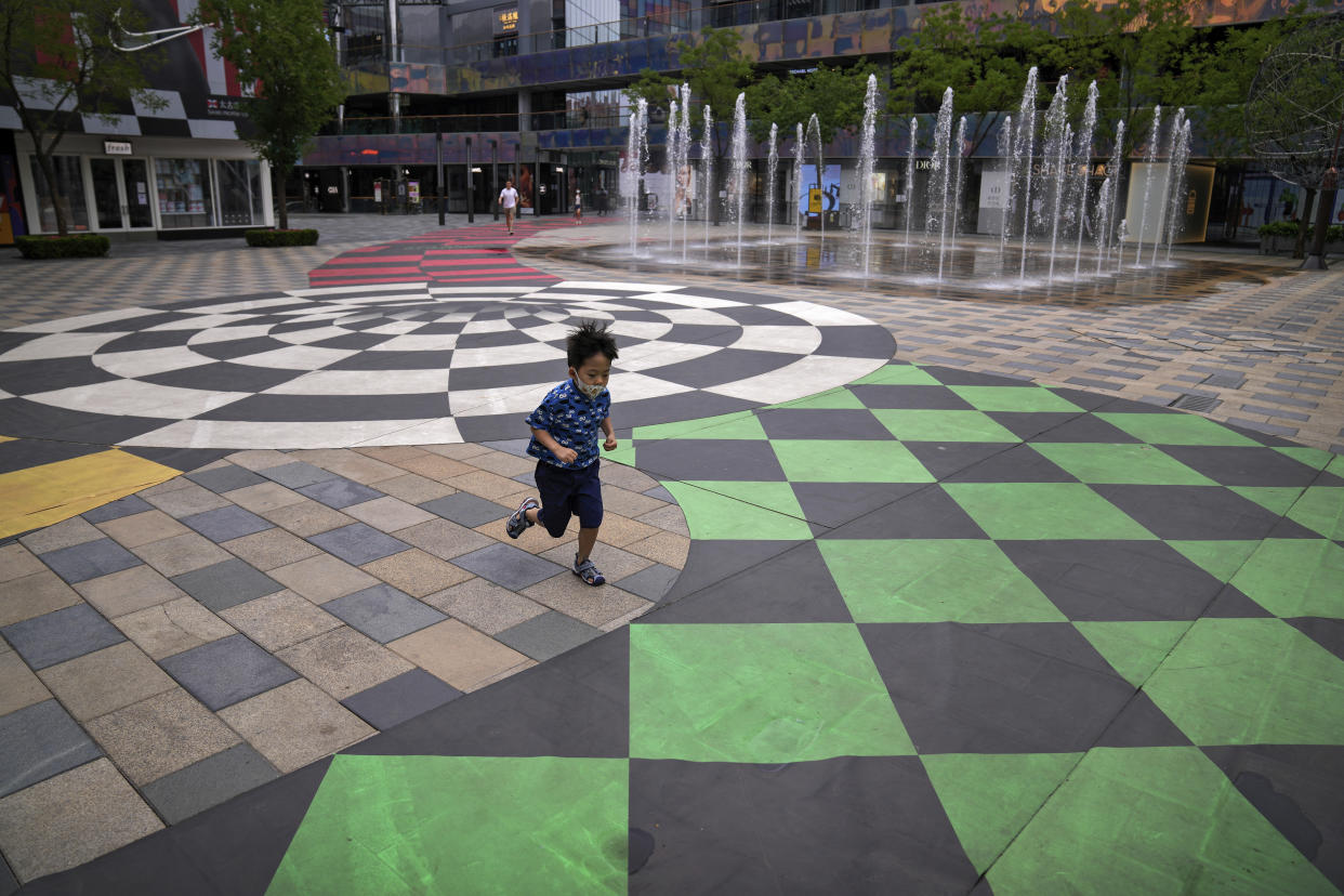 A child wearing a face mask runs through a deserted shopping mall where most shops have ordered to closed as part of COVID-19 controls in Beijing, Monday, June 13, 2022. China's capital has put school online in one of its major districts amid a new COVID-19 outbreak linked to a nightclub, while life has yet to return to normal in Shanghai despite the lifting of a more than two month-long lockdown. (AP Photo/Andy Wong)