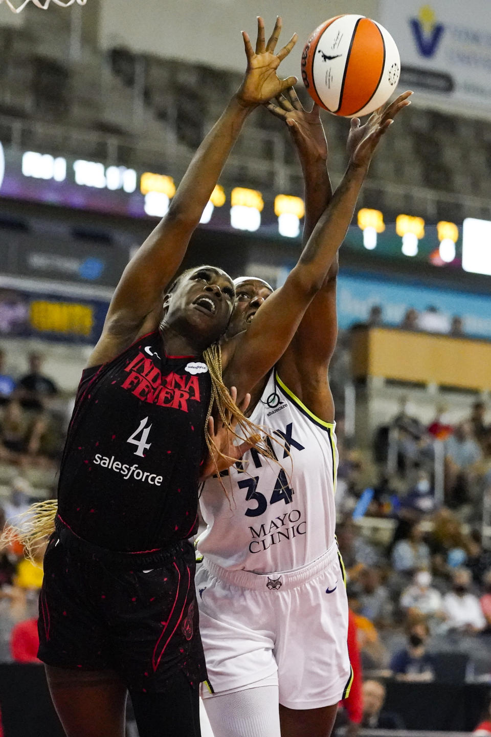 Indiana Fever center Queen Egbo (4) and Minnesota Lynx center Sylvia Fowles (34) go for a rebound in the first half of a WNBA basketball game in Indianapolis, Friday, July 15, 2022. (AP Photo/Michael Conroy)