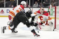 Los Angeles Kings defenseman Mikey Anderson, center, shoots the puck as Calgary Flames defenseman Ilya Solovyov, left, and goaltender Jacob Markstrom defend during the second period of an NHL hockey game Thursday, April 11, 2024, in Los Angeles. (AP Photo/Mark J. Terrill)