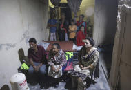 In this May 14, 2019, photo Pakistani Christian Natasha Masih, right front, sits with her family members during an interview in Faisalabad, Pakistan. Natasha begged her mother to bring her home from China, but it took an elaborate scheme devised by a small cabal of Christian men in her hometown of Faisalabad, in Pakistan's Punjab province, to orchestrate her escape from what began as an unhappy marriage, and ended in prostitution. (AP Photo/K.M. Chaudary)