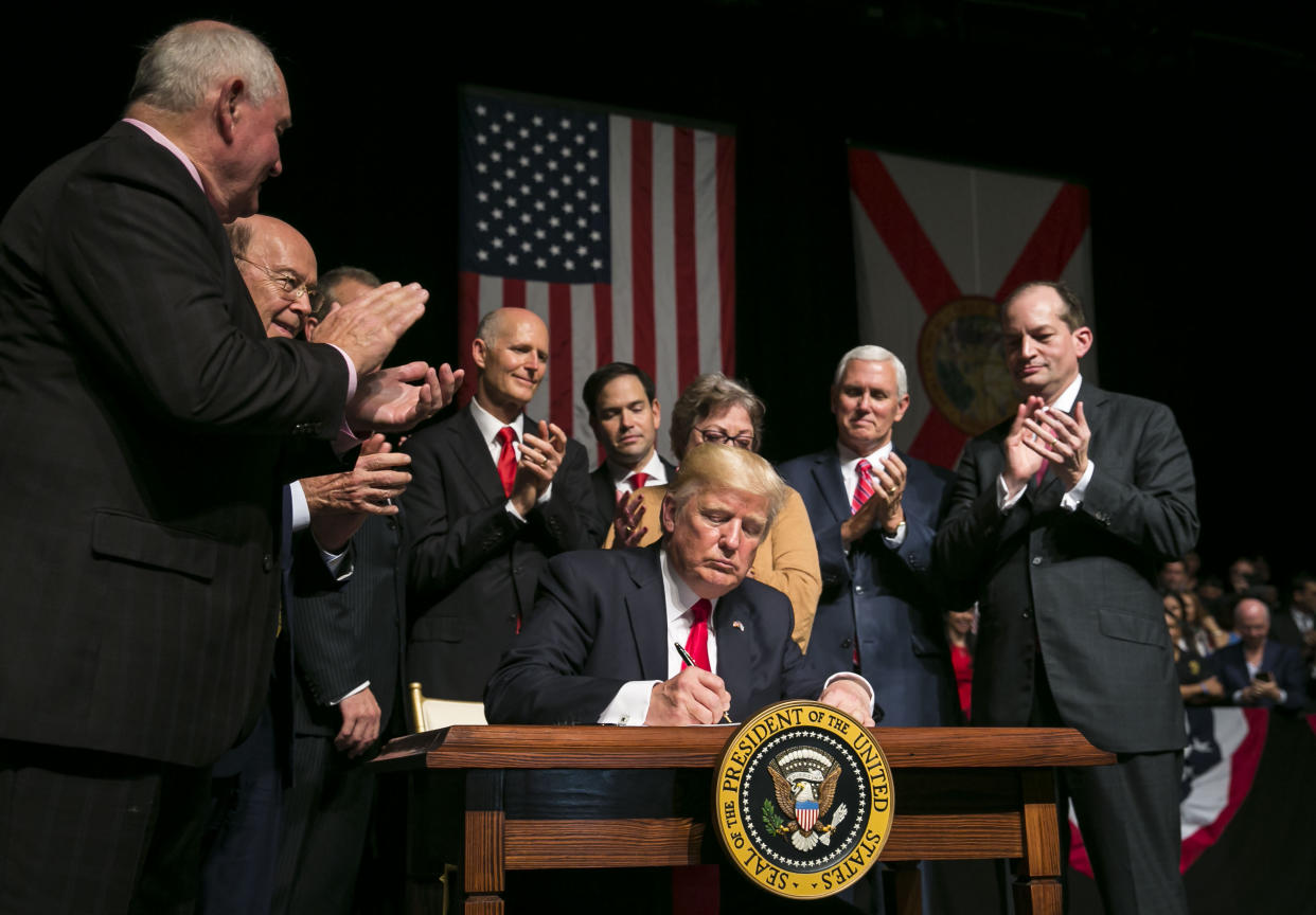 El presidente Donald Trump, junto con líderes republicanos, firma documentos políticos en Miami el 16 de junio de 2017, revirtiendo cambios de la era de Obama que aliviaron las relaciones entre Estados Unidos y Cuba. (Al Drago/The New York Times)