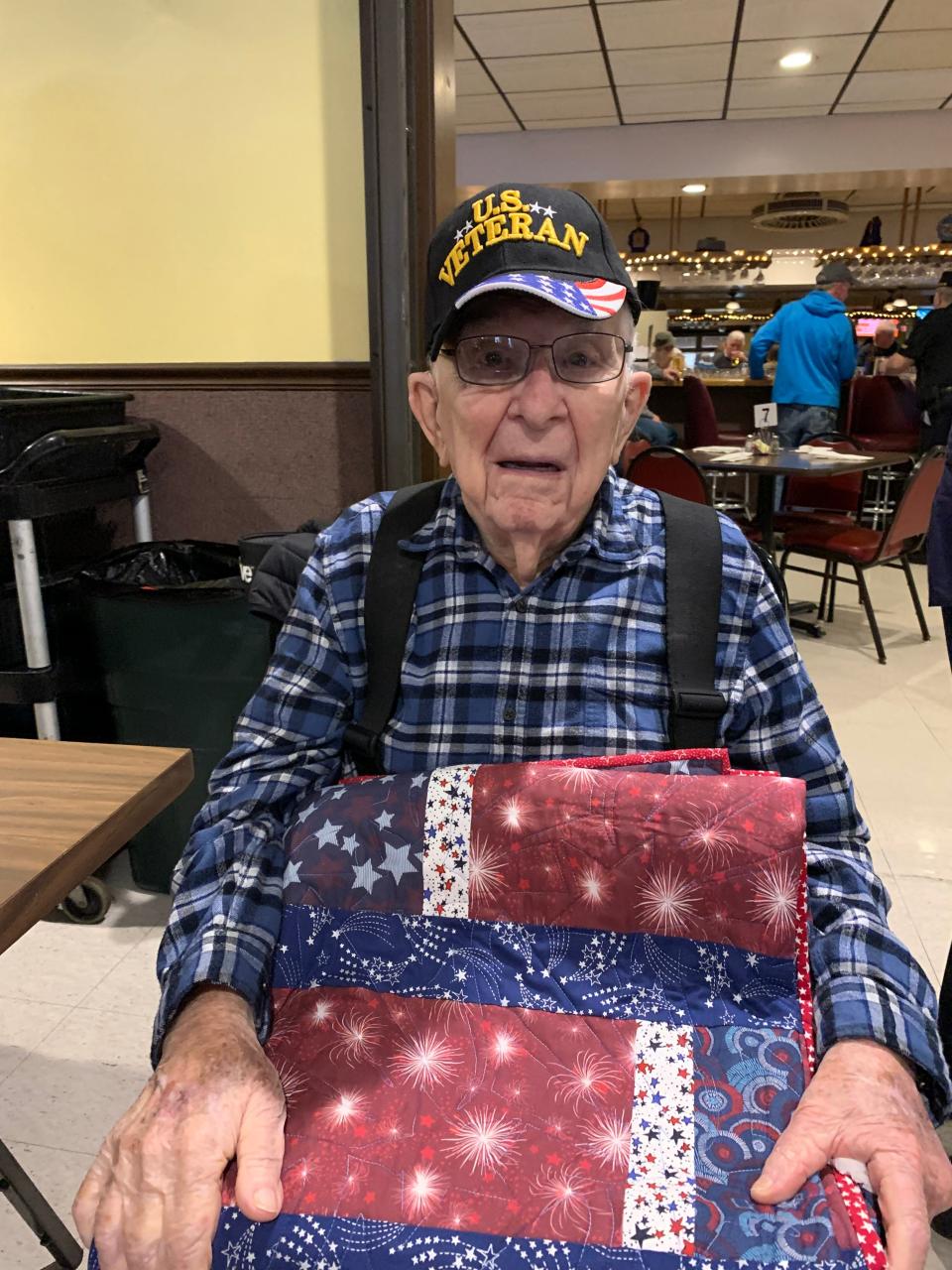Herbert Ray holds the Quilt of Valor presented to him by the American Legion Auxiliary of Bloomington on Friday, Dec. 1, 2023.