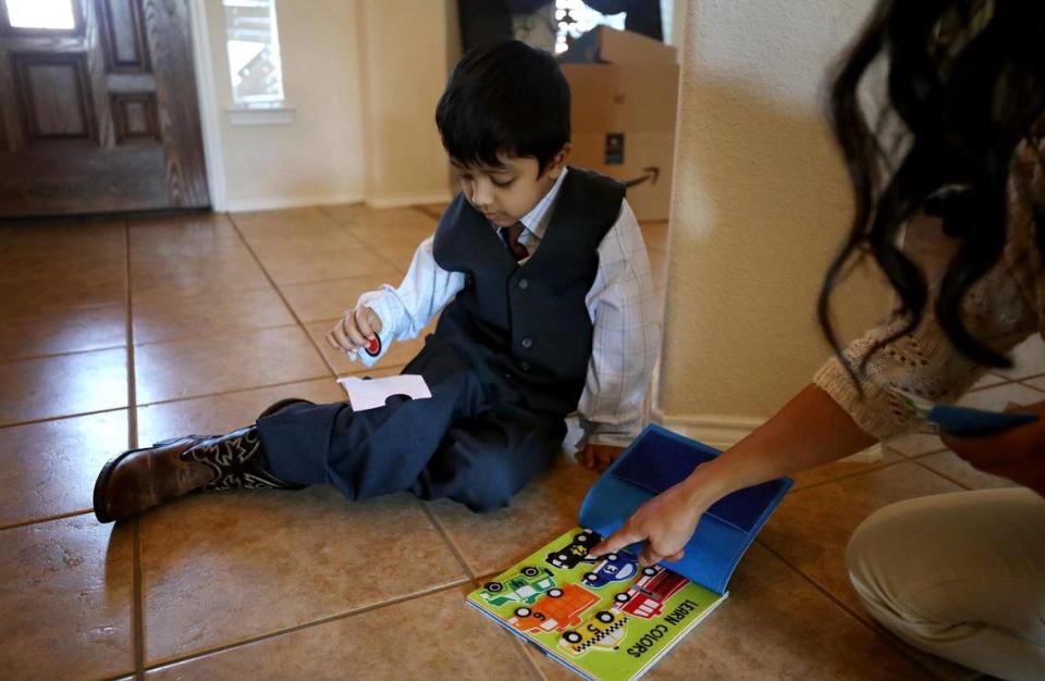 Kenneth Moses, 4, works with behavior therapist Erica Belle.