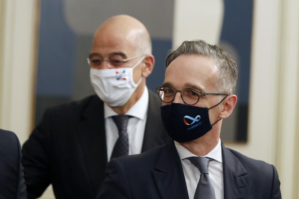 Germany's foreign minister Heiko Maas, right, and his Greek counterpart Nikos Dendias attend a meeting with Greece's Prime Minister Kyriakos Mitsotakis at Maximos Mansion in Athens, Tuesday, Oct. 13, 2020. Maas on Tuesday criticized Turkey for "unilateral steps" in the eastern Mediterranean that are undercutting efforts to de-escalate tensions with Greece and Cyprus over sea boundaries and drilling rights. (AP Photo/Thanassis Stavrakis)