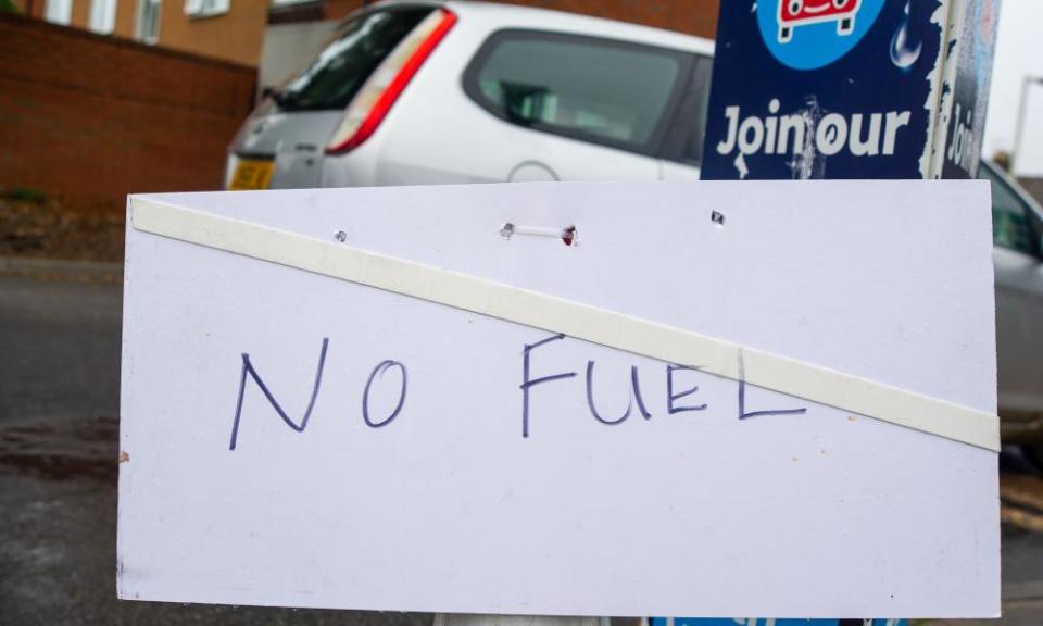 A petrol station forecourt with a 'no fuel' sign