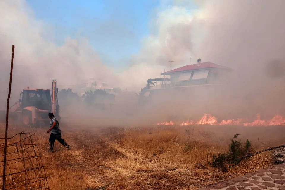 <p>En la imagen, un hombre corre mientras el fuego se acerca a las viviendas de Vatera, ciudad situada al sur de la isla griega de Lesbos, a unos 55 kilómetros de la capital, Mitilene, cuyas cercanías están siendo arrasadas por un terrible incendio. (Foto: Manolis Lagoutaris / AFP / Getty Images).</p> 