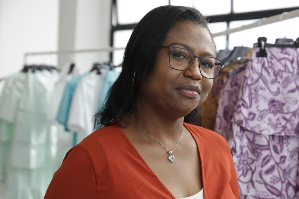 Fashion designer Joy Meribe poses in front of her creations , in Milan, Italy, Sunday, Sept. 27, 2020. (AP Photo/Luca Bruno).