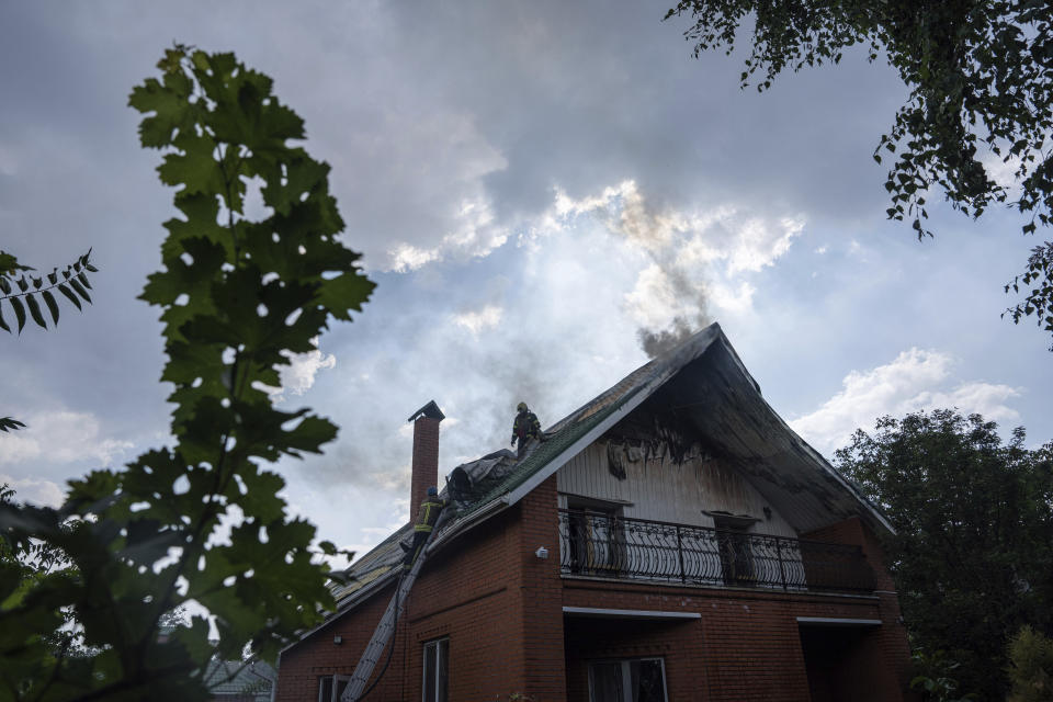 A rescue worker stands on the roof of a house damaged by a Russian attack in Mykolaiv, Ukraine, Friday, Aug. 5, 2022. (AP Photo/Evgeniy Maloletka)